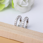 Lumière Pavé Huggie Hoop Earrings – pair of silver huggie hoops flat lay
