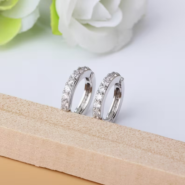 Lumière Pavé Huggie Hoop Earrings – pair of silver huggie hoops flat lay