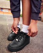 Nike Air Force 1 '07 Black Sneaker – lifestyle shot being laced up on street