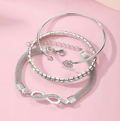 Argenté Trio Bracelet Set – Silver-tone infinity, crystal tennis & heart charm bangles on pink background